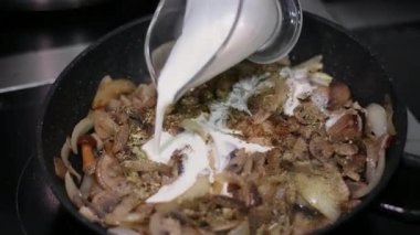Pan 'da kaynamış kremalı mantar sosu ve Tagliatelle yumurtasının Pan' a indirilmesi. İtalyan Pasta Tabağı Pişirme Görüntüsü. Yüksek kalite 4k görüntü