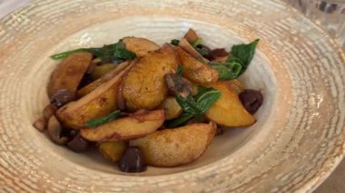 Ispanak ve mantar soslu lüks vejetaryen yemekleri olan bir restoranda kızarmış patatesler bir tabakta duruyor. Yüksek kalite 4k görüntü