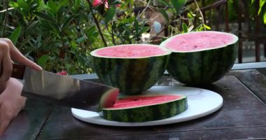 Bıçakla karpuzu kolay yenen porsiyonlara ayırmak. Yüksek kalite 4k görüntü