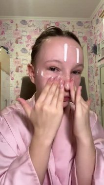 Genç bir kadının burun derisine masaj yapmak için ellerini kullanması, cilt dokusunu geliştirmeye odaklanması ve belirli bölgeleri tedavi etmesi, kusursuz cilt için nazik bir güzellik örneği. Yüksek kalite 4k görüntü