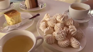 Bir tabak süzme peynirli güveçte beyaz çay fincanı ve kek. Üç bardak çikolatalı, üç fincan da üç bardak. Yüksek kalite 4k görüntü