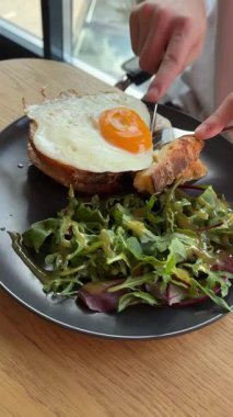 Tanımlanamayan kişi yaz tatillerinde otel restoranında çörekli kızarmış yumurta yiyor. Proteinli geleneksel İngiliz kahvaltısı. Terasta güneşli bir gün. Yüksek kalite 4k görüntü