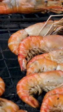 Izgarada karidesler pişiyor, diğer tarafa takla atıyor. Yüksek kalite 4k görüntü