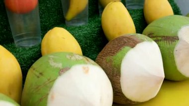 Canlı tropikal meyve tezgahında olgun ananas, mango ve hindistan cevizi sergilenir. Kırsal bir ortamda bolluk ve tazelik gösterilir. Yüksek kalite 4k görüntü
