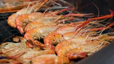 Izgarada karidesler pişiyor, diğer tarafa takla atıyor. Yüksek kalite 4k görüntü