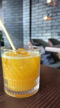 Yaz aylarında bir restoran kafeteryasındaki taze portakal suyuna bir bardak buz ve pipet kokteyli ekleyin. Yüksek kalite 4k görüntü