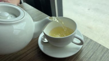 Turunçgil çayını yakın plan bardağa dolduruyorum. Nane ve portakallı taze bitki çayı, sağlıklı bir sabah, detoks içeceği. Yüksek kalite 4k görüntü