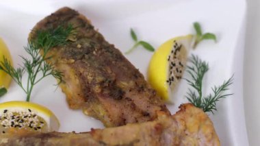 Izgara için maşa tutan bir kadın eli, balığın yağda kavrulmasını sağlar. Yüksek kalite 4k görüntü