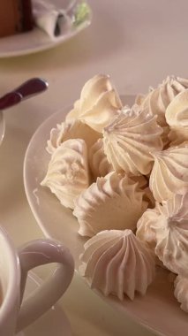 Bir tabak süzme peynirli güveçte beyaz çay fincanı ve kek. Üç bardak çikolatalı, üç fincan da üç bardak. Yüksek kalite 4k görüntü