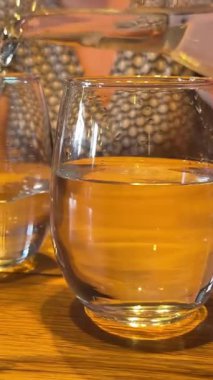 Bir bardağa içilemeyen su dökmek. Koyu yeşil arka plandaki bir bardağa köpüklerle kirlenmiş bayat içme suyu dökülüyor. İçki konsepti, sağlıklı. Yüksek kalite 4k görüntü