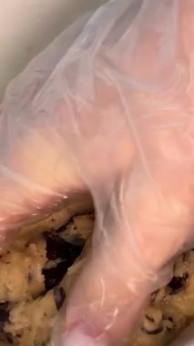 4K 'de şeffaf bir cam kasede çikolatalı kurabiye yapıp karıştırıyorum. Çikolata parçacıklı kurabiyeleri adım adım hazırlama kavramı. Koyu çikolata parçacıklı kurabiye hamuru yapma işlemi