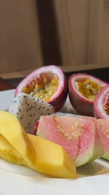 Meyve, tutku meyveli mango ve ejderha meyvesi şeklinde nefis iştah açıcı bir kahvaltı. Otel büfesindeki bir tabakta. Yüksek kalite 4k görüntü