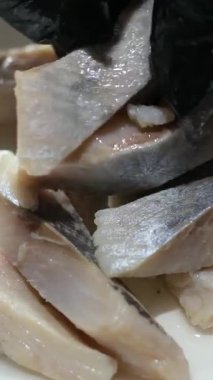 Tabakta ringa balığı servis et. Restoranda yemek pişir. Temizlenmiş filetolar tabakta parçalara ayrılsın. İsteyen istemciye sunmadan önce aperatif sunumunun son detaylarını tamamlayan dikkatli usta