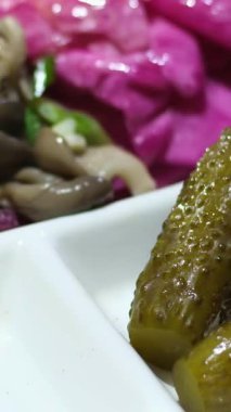 Aşçı beyaz bir tabakta salatalık turşusu ve siyah eldiven servis eder. Yüksek kalite 4k görüntü
