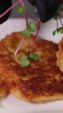 Ekşi kremalı ve siyah tabakta salatalıklı patates gözlemesi. Yüksek kalite 4k görüntü