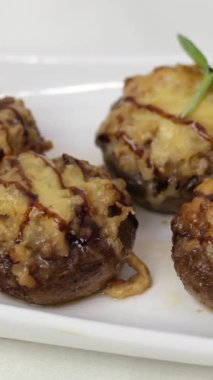 Fırından doğruca tabağa doldurulmuş mantar servisi. Doldurulmuş peynirli şampiyonlar