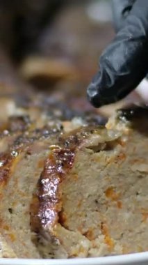 Şeften özel bir yemek, üzüm, zeytin, limon ve kurutulmuş portakalla süslenmiş salata yapraklarıyla servis edilmiş doldurulmuş balık. Restorandaki masada bir tabak deniz ürünü ve sebze salatası var..