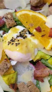 Salata, tuzlu somon, avokado, haşlanmış yumurta ve yeşil tabakta sebze. Yumuşak odaklanma. Yavaş çekim el kamerası videosu. Sağlıklı beslenme teması. Yüksek kalite 4k görüntü