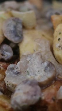 Kremalı mantar soslu yumuşak tavuk yanında altın patates ve ızgara sebzeyle birlikte mavi seramik tabakta ağır çekimde servis edilir. Mantar patatesli kremalı