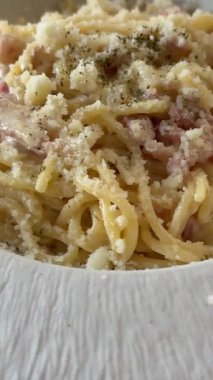 İtalyan makarnası pişirmek. Şampiyon Fetuçin ve fesleğenli krema. Şef makarna maşasıyla makarnayı karıştırır. Yakın plan, iştah açıcı yemek. Yüksek kalite 4k görüntü