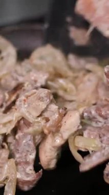 Yakın çekim, soğanlı leziz et ve açık ateş. Büyük bir tencerede ateş üstünde pilav pişirmek. Kızarmış et, tavada soğan. Üst Manzara. Yüksek kalite 4k görüntü