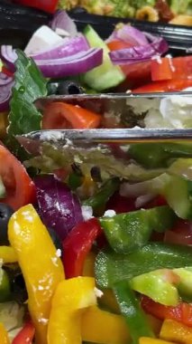 Kapalı alandaki açık büfe yemekleri için çeşitli taze salatalar sergileniyor. Yüksek kalite 4k görüntü