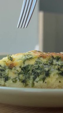 Bir kafede ıspanak ve peynirli turta duruyor. Bir kız elinde çatalla yiyor. Kahvaltı arka planda kaldı. Bir pencere ve bir adam bekliyor. Yüksek kalite 4k görüntü