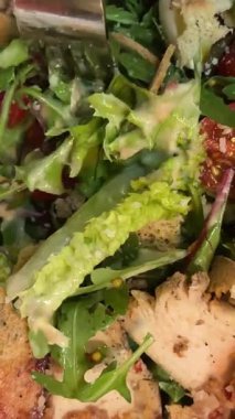 İçinde tavuk, parmesan peyniri, domates, kızarmış ekmek, marul yaprağı, keten tohumu, ayçiçeği ve susam tohumu olan bir kâse dolusu sezar salatası. Yüksek kalite 4k görüntü