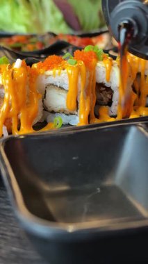 Suşi için soya sosunu lezzetli Asya yemeklerine dök California usulü zencefilli sosu restoran balık büfesine koy. Yüksek kalite 4k görüntü