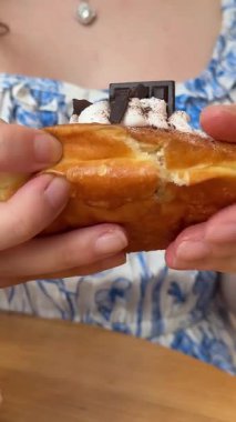 Bir kadının sabah kahvesinin keyfini çıkardığı sakin bir an. Mor çiçekli ve kahvaltılık pastalı bir pencere kenarında. Huzurlu ve huzurlu bir ortam. Parlak odada sabah kahvesinin tadını çıkaran bir kadın. Yüksek kalite 4k