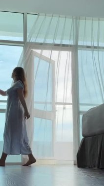 Mavi elbiseli kız perdeleri kapatıyor otel odasındaki daireyi kiralıyor tentenin arkasında ev zevki perdeleri alıyor. Yüksek kalite 4k görüntü