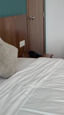 4K video modern lüks otel odasının iç tasarımı ve dekorasyonu beyaz ve gri yatak çarşafı ve battaniyesi, beyaz sandalye, sıcak yatak başlığı, 3D balkonlu daire dekorasyonu. Yüksek