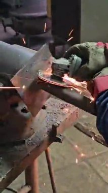 Metal kesip kesme makinesiyle kıvılcım çıkaran bir işçi. Yüksek kalite 4k görüntü