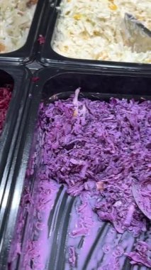 Kapalı alandaki açık büfe yemekleri için çeşitli taze salatalar sergileniyor. Yüksek kalite 4k görüntü