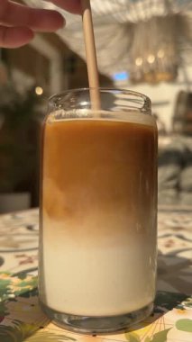 Bir Kişi Çay Kaşığıyla Karışık Bir fincan Taze Sütlü Lezzetli Kahve. Buzlu latte karışımı.