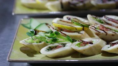 Siyah lateks eldivenli bir tabağa konmuş köfte. Şölende servis edilen bir restoranda zeytin yeşili de ekle. Yüksek kalite 4k görüntü