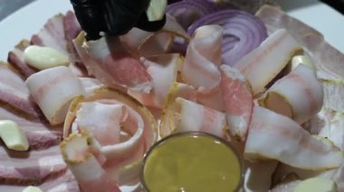 Ukrayna 'da domuz yağı servis etmek ince dilimli bir tabağa koymak domuz yağı sarımsaklı et ve mavi hardallı soğan halkaları ile birlikte votka ile lezzetli bir restoranda. Yüksek kalite 4k görüntü