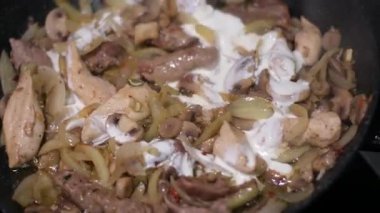 Kızarmış soğana kremalı ekşi krema ve et ekle. Yüksek kalite 4k görüntü