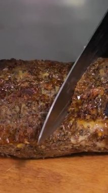 Ahşap bir tahtanın üzerinde siyah lateks eldivenlerle et balyk ellerini keserek, et dilimleyerek, ev yapımı sigara içerek lezzetli bir et dilimleyerek. Yüksek kalite 4k görüntü