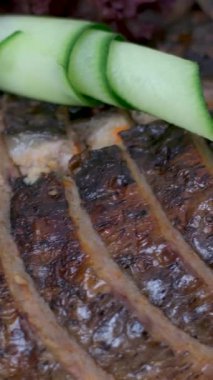 Salatalık sebzeleri için süslenmiş beyaz bir tabakta içi doldurulmuş balık masasında domatesler yeri doldurulamaz bir yemek. Yüksek kalite 4k görüntü