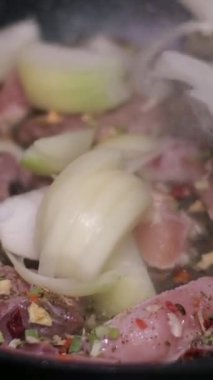 Tavada kızartılmış bifteğe soğan eklemek, karıştırmak. Yüksek kalite 4k görüntü