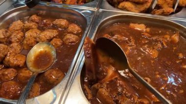 Zengin domates soslu köfte yakın çekim kapaklı ısıtılmış metal bir tencerede servis edilir. Yüksek kalite 4k görüntü