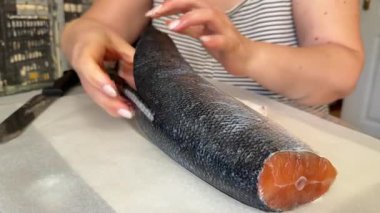 Taze deniz somonu beyaz eldivenli bir şefin elleriyle kesilir ve suşi barında yemek hazırlamak için derisini yüzülür. Yüksek kalite 4k görüntü
