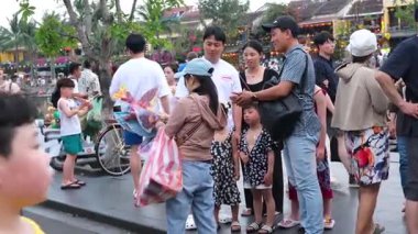 Otantik Hoi Bir Vietnam yaşam tarzı turistlerin canlı kültürel seyahat sahnelerinde yürüdüğü eski şehir caddeleri nehirde yüzen tekneler ve kafede eğlenen insanlar. Hoi Bir Vietnam 10.02.2025