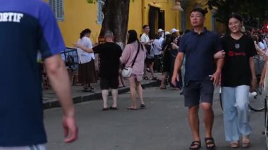 Renkli Hoi Dar sokakları keşfeden insanlarla dolu bir Vietnam nehir kenarındaki kafelerde dinlenen tribünlerde dinlenen ve su üzerinde hareket eden tekneler canlı bir yaşam tarzı kültürel seyahat Vietnam Hoi 10.02.2025