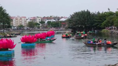 Hoi 'de günlük hayat. Vietnam' da sokaklarda yürüyen insanlar nehir kenarındaki teknelerde dinleniyor. Kültürel cazibenin tadını çıkarıyorlar.