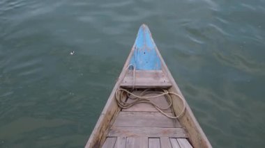 Eski paslı çapa ipte sallanıyor ve denizin yüzeyinde yüzen ahşap bir geminin kıç tarafında sendeliyor. Gemide yelken açmak, gemide yüzmek. # Eski ahşap tekne #