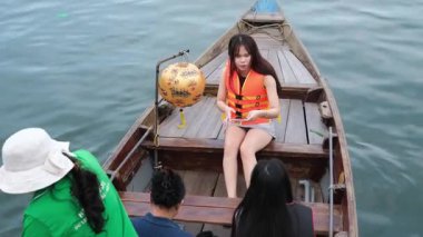 Gölde kano süren genç bir kadın yaz günü akıllı telefonuyla fotoğraf çekiyor. Macera seyahati keyfi, konsept, yaşam tarzı hoi Bir Vietnam 10.02.2025