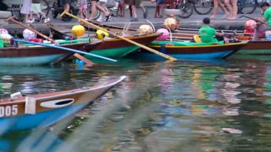 Günbatımında Hoi An Antik Kasabası 'nda fener tekneleri, nehir kenarındaki kalabalıklar ve kültürel turizm, festivaller ve Vietnam seyahati için ideal sokak lambaları gösteriliyor. Hoi Bir Vietnam 10.02.2025