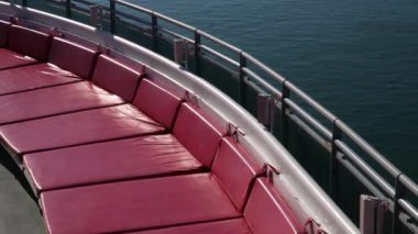 Havuz, jakuzi, kırmızı ve mavi güneş pansiyonları ve güzel bir sahil şehrinin panoramik manzarası olan lüks yolcu gemisi güvertesi. Seyahat, boş zaman ve tatil görüntüleri için mükemmel..